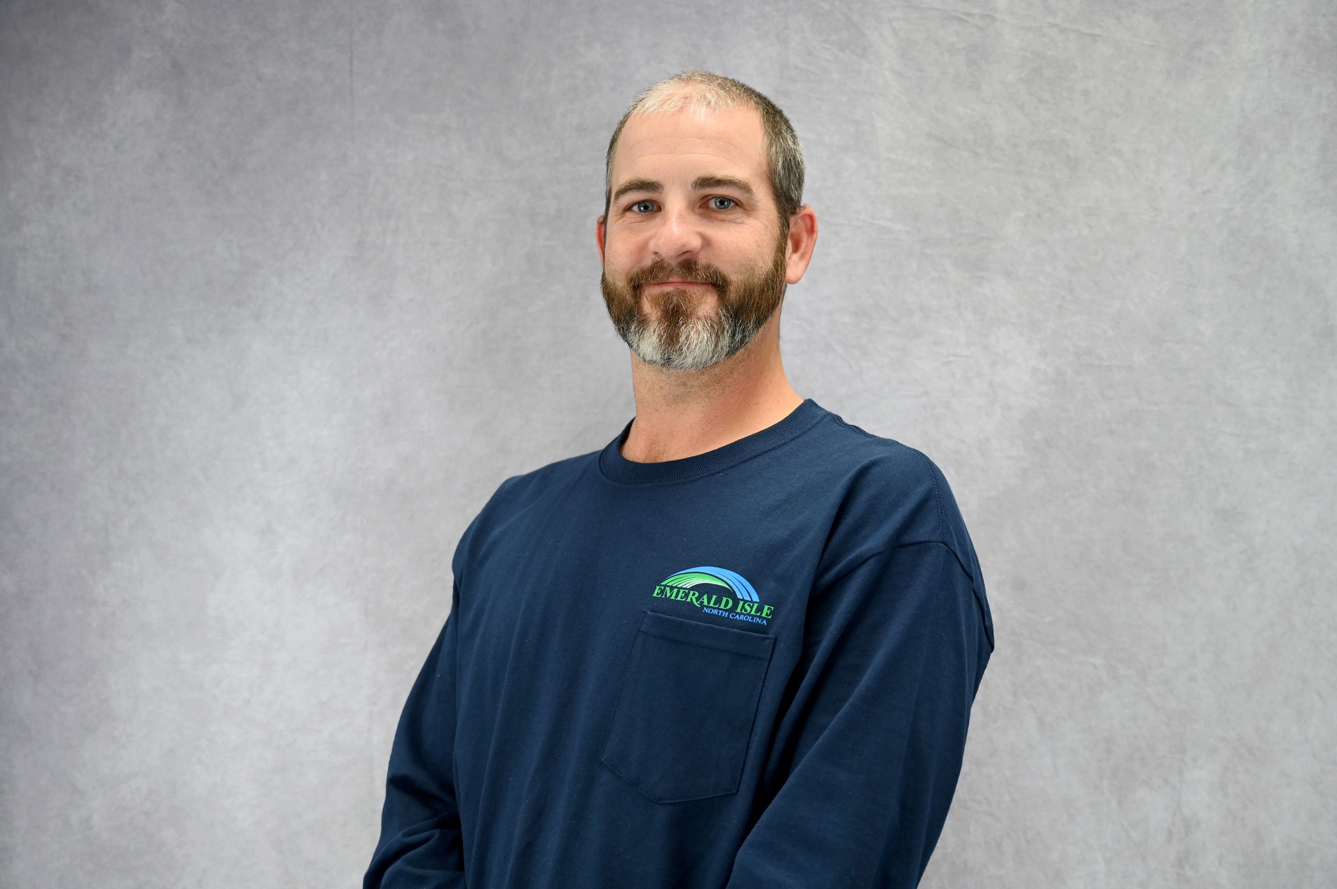 Man in dark blue pullover sweater with Emerald Isle logo